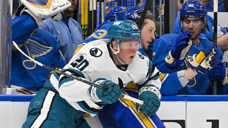 Mar 30, 2024; St. Louis, Missouri, USA; San Jose Sharks left wing Fabian Zetterlund (20) checks St. Louis Blues left wing Jake Neighbours (63) during the first period at Enterprise Center. Mandatory Credit: Jeff Curry-USA TODAY Sports