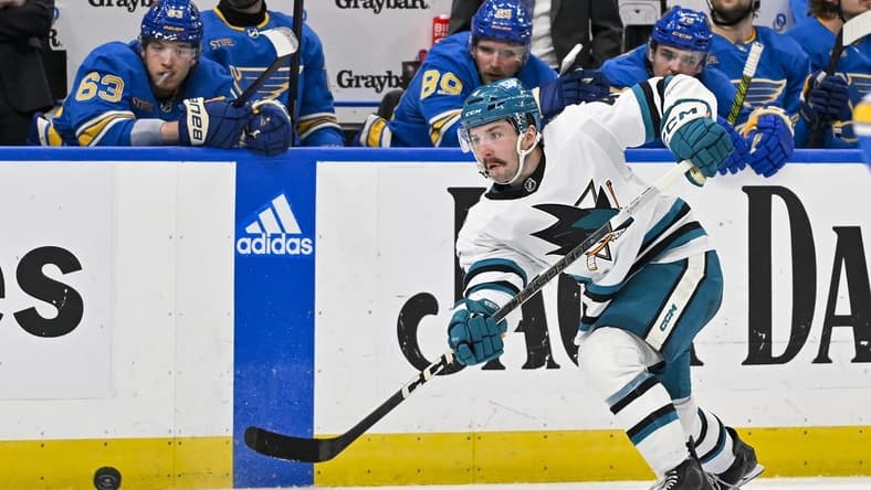 Mar 30, 2024; St. Louis, Missouri, USA;  San Jose Sharks defenseman Kyle Burroughs (4) shoots against the St. Louis Blues during the third period at Enterprise Center. Mandatory Credit: Jeff Curry-USA TODAY Sports