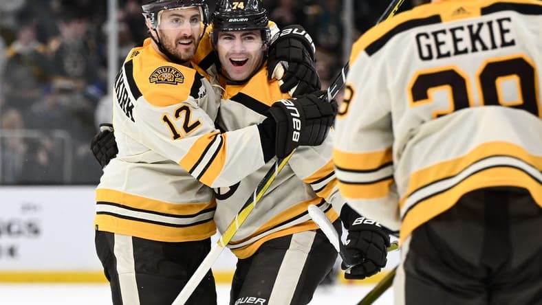 Mar 21, 2024; Boston, Massachusetts, USA; Boston Bruins left wing Jake DeBrusk (74) celebrates with defenseman Kevin Shattenkirk (12) and center Morgan Geekie (39) after scoring a goal against the New York Rangers during the first period at the TD Garden. Mandatory Credit: Brian Fluharty-USA TODAY Sports