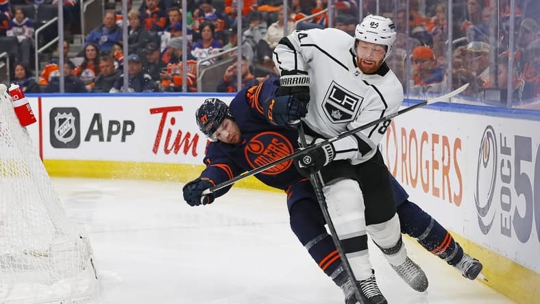 Mar 28, 2024; Edmonton, Alberta, CAN; Edmonton Oilers forward Warren Foegele (37) tries to knock Los Angeles Kings defensemen Vladislav Gavrikov (84) off the puck during the third period at Rogers Place. Mandatory Credit: Perry Nelson-USA TODAY Sports