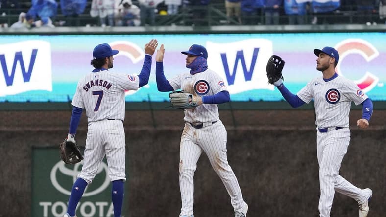 Apr 1, 2024; Chicago, Illinois, USA; Chicago Cubs shortstop Dansby Swanson (7), left fielder Ian Happ (8), and center fielder Cody Bellinger (24) celebrate their win against the Colorado Rockies at Wrigley Field. Mandatory Credit: David Banks-USA TODAY Sports