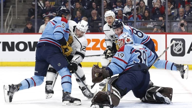 Apr 1, 2024; Winnipeg, Manitoba, CAN; Winnipeg Jets defenseman Brenden Dillon (5) and Los Angeles Kings left wing Kevin Fiala (22) scramble for the puck in front of Winnipeg Jets goaltender Laurent Brossoit (39) in the first period at Canada Life Centre. Mandatory Credit: James Carey Lauder-USA TODAY Sports