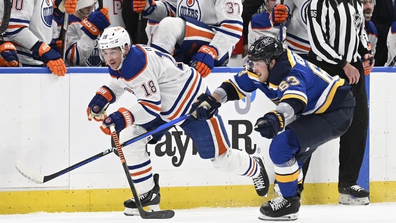 Apr 1, 2024; St. Louis, Missouri, USA; St. Louis Blues left wing Jake Neighbours (63) pressures Edmonton Oilers left wing Zach Hyman (18) during the third period at Enterprise Center. Mandatory Credit: Jeff Le-USA TODAY Sports