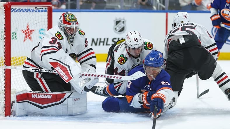 Apr 2, 2024; Elmont, New York, USA; New York Islanders left wing Anders Lee (27) attempts to take a shot on Chicago Blackhawks goaltender Petr Mrazek (34) during the second period at UBS Arena. Mandatory Credit: Thomas Salus-USA TODAY Sports