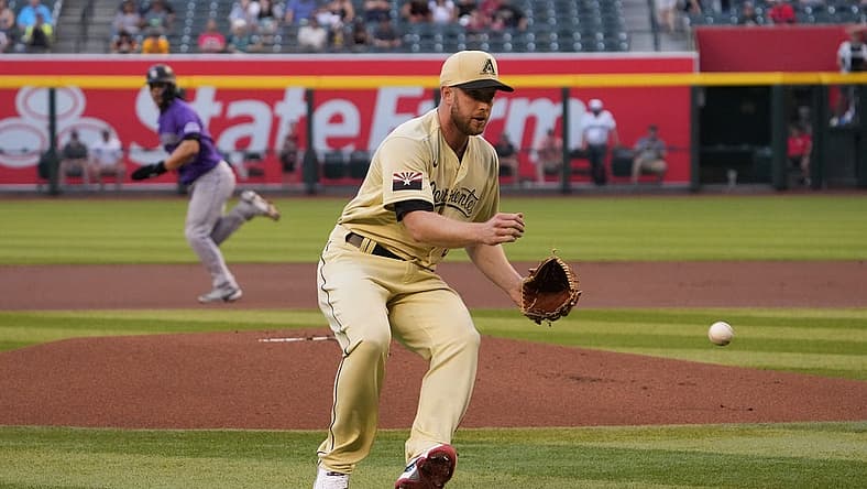 May 6, 2022; Phoenix, Arizona, USA; Arizona Diamondbacks starting pitcher Merrill Kelly (29) fields a ball against the Colorado Rockies during the first inning at Chase Field. Mandatory Credit: Joe Camporeale-USA TODAY Sports