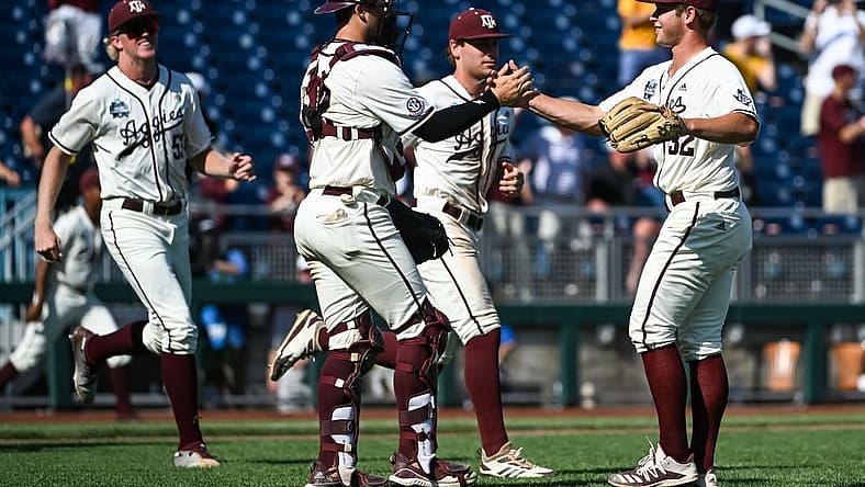Jun 19, 2022; Omaha, NE, USA; Texas A&M Aggies pitcher Brad Rudis (32) and catcher Troy Claunch (12) celebrate the win against the Texas Longhorns at Charles Schwab Field. Mandatory Credit: Steven Branscombe-USA TODAY Sports