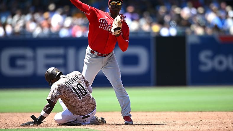 Jun 26, 2022; San Diego, California, USA; Philadelphia Phillies shortstop Didi Gregorius (top) throws to first base late after forcing out San Diego Padres left fielder Jurickson Profar (10) at second base during the third inning at Petco Park. Mandatory Credit: Orlando Ramirez-USA TODAY Sports