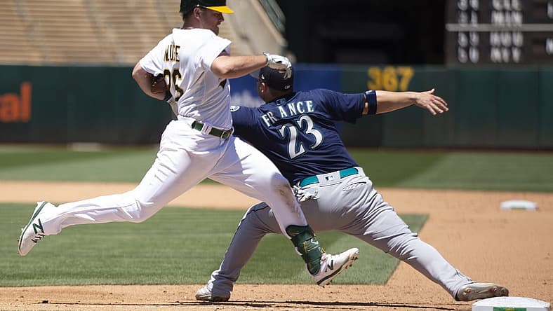 Jun 23, 2022; Oakland, California, USA; Seattle Mariners first baseman Ty France (23) gets his glove caught under the arm of Oakland Athletics third baseman Sheldon Neuse (26) as he reaches for the throw during the fifth inning at RingCentral Coliseum. France was injured on the play, and left the game. Neuse was safe at first. Mandatory Credit: D. Ross Cameron-USA TODAY Sports