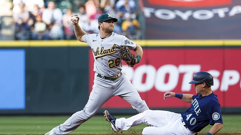 Jul 1, 2022; Seattle, Washington, USA; Oakland Athletics third baseman Sheldon Neuse (26) attempts to turn a double play against Seattle Mariners catcher Andrew Knapp (40) during the third inning at T-Mobile Park. The runner was safe at first. Mandatory Credit: Joe Nicholson-USA TODAY Sports