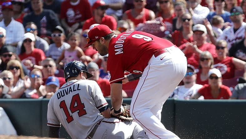 Jul 2, 2022; Cincinnati, Ohio, USA; Atlanta Braves left fielder Adam Duvall (14) is picked-off at first by Cincinnati Reds first baseman Mike Moustakas (9) during the second inning at Great American Ball Park. Mandatory Credit: David Kohl-USA TODAY Sports