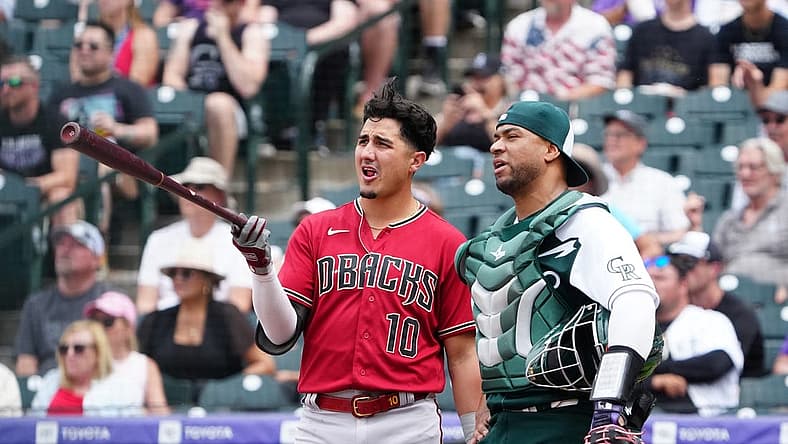 Jul 3, 2022; Denver, Colorado, USA; Arizona Diamondbacks third baseman Josh Rojas (10) and Colorado Rockies catcher Elias Diaz (35) talks during a review in the sixth inning at Coors Field. Mandatory Credit: Ron Chenoy-USA TODAY Sports
