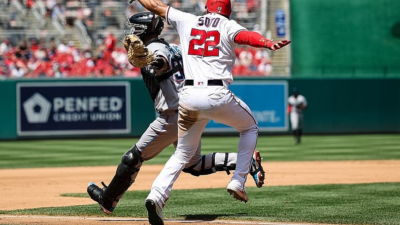 Jul 3, 2022; Washington, District of Columbia, USA; Washington Nationals right fielder Juan Soto (22) is called out after attempting to avoid the tag of Miami Marlins catcher Jacob Stallings (58) during the fourth inning at Nationals Park. Mandatory Credit: Scott Taetsch-USA TODAY Sports