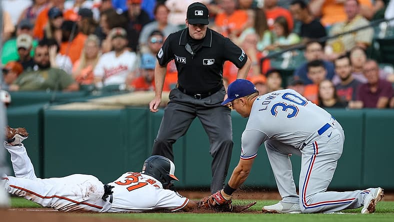 Jul 5, 2022; Baltimore, Maryland, USA; Baltimore Orioles center fielder Cedric Mullins (31) is tagged out by Texas Rangers first baseman Nathaniel Lowe (30) during the first inning at Oriole Park at Camden Yards. Mandatory Credit: Scott Taetsch-USA TODAY Sports