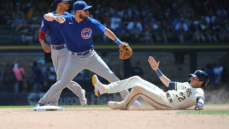 Jul 6, 2022; Milwaukee, Wisconsin, USA; Milwaukee Brewers left fielder Christian Yelich (22) attempts to break up the double play throw of Chicago Cubs third baseman Patrick Wisdom (16) in the fourth inning at American Family Field. Mandatory Credit: Michael McLoone-USA TODAY Sports