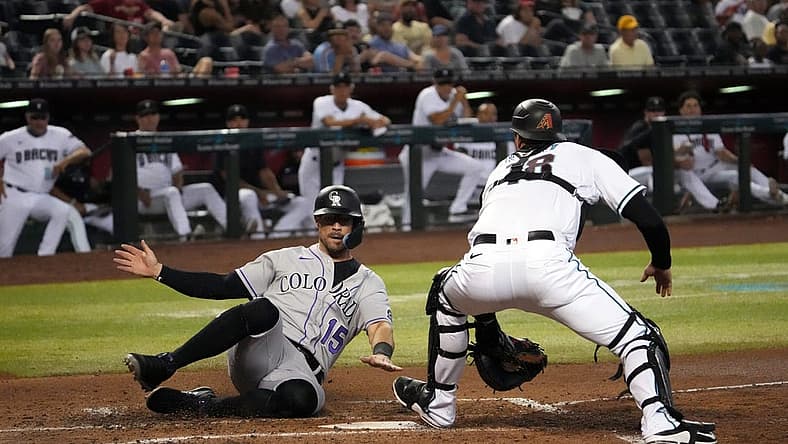 Jul 7, 2022; Phoenix, Arizona, USA; Colorado Rockies right fielder Randal Grichuk (15) beats the tag of Arizona Diamondbacks catcher Carson Kelly (18) to score a run during the fourth inning at Chase Field. Mandatory Credit: Joe Camporeale-USA TODAY Sports