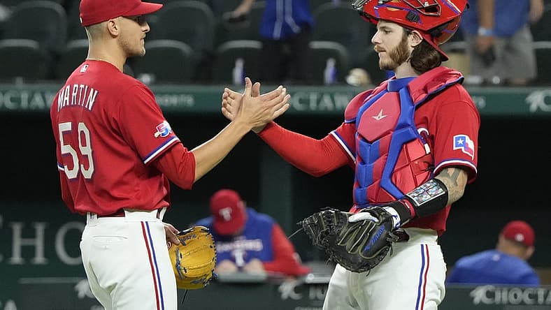Jul 8, 2022; Arlington, Texas, USA; Texas Rangers relief pitcher Brett Martin (59) and catcher Jonah Heim (28) celebrate after defeating the Minnesota Twins at Globe Life Field. The Rangers won 6-5. Mandatory Credit: Jim Cowsert-USA TODAY Sports