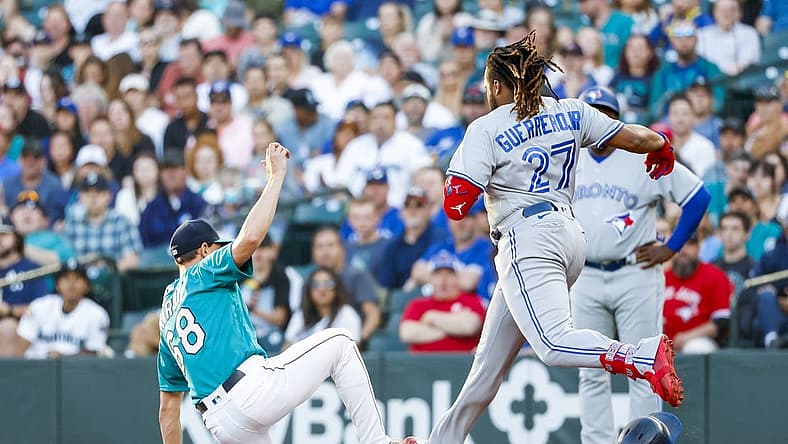 Jul 8, 2022; Seattle, Washington, USA; Seattle Mariners starting pitcher George Kirby (68) steps on first base before Toronto Blue Jays designated hitter Vladimir Guerrero Jr. (27) for a groundout during the third inning at T-Mobile Park. Mandatory Credit: Joe Nicholson-USA TODAY Sports