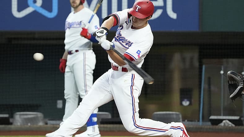 Jul 9, 2022; Arlington, Texas, USA; Texas Rangers shortstop Corey Seager (5) hits for a single against the Minnesota Twins during the first inning at Globe Life Field. Mandatory Credit: Jim Cowsert-USA TODAY Sports