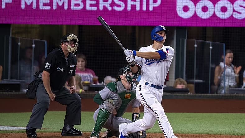Jul 11, 2022; Arlington, Texas, USA; Texas Rangers shortstop Corey Seager (5) hits a home run against the Oakland Athletics during the fifth inning at Globe Life Field. Mandatory Credit: Jerome Miron-USA TODAY Sports