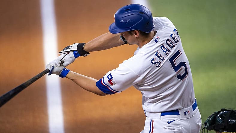 Jul 13, 2022; Arlington, Texas, USA; Texas Rangers designated hitter Corey Seager (5) drives in a run against the Oakland Athletics during the first inning at Globe Life Field. Mandatory Credit: Jerome Miron-USA TODAY Sports
