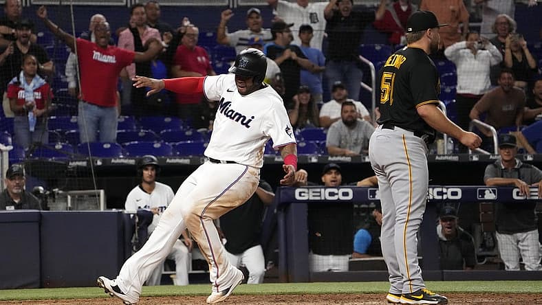 Jul 13, 2022; Miami, Florida, USA; Miami Marlins first baseman Jesus Aguilar (99) scores the game winning run on a wild pitch by Pittsburgh Pirates relief pitcher David Bednar (51) in the tenth inning at loanDepot park. Mandatory Credit: Jasen Vinlove-USA TODAY Sports