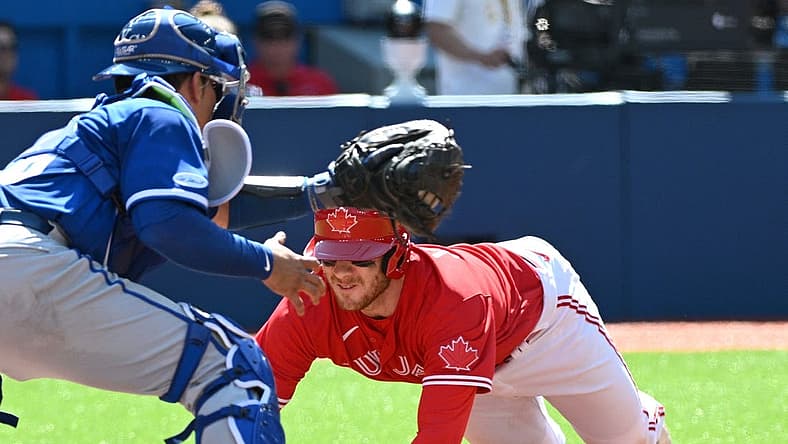 Jul 16, 2022; Toronto, Ontario, CAN;  Toronto Blue Jays catcher Danny Jansen (9) slides to score past Kansas City Royals catcher Freddy Fermin (78) in the third inning at Rogers Centre. Mandatory Credit: Dan Hamilton-USA TODAY Sports