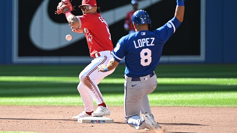 Jul 16, 2022; Toronto, Ontario, CAN;  Toronto Blue Jays second baseman Santiago Espinal (5) mishandles the ball trying for a double play after forcing out Kansas City Royals third baseman Nicky Lopez (8) in the seventh inning at Rogers Centre. Mandatory Credit: Dan Hamilton-USA TODAY Sports