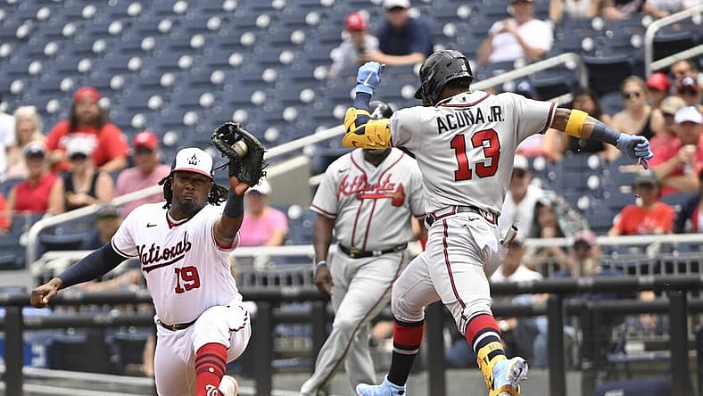 Jul 17, 2022; Washington, District of Columbia, USA; Washington Nationals first baseman Josh Bell (19) reaches to make a catch at first base as Atlanta Braves right fielder Ronald Acuna Jr. (13) stretches for the base during the first inning at Nationals Park. Mandatory Credit: James A. Pittman-USA TODAY Sports