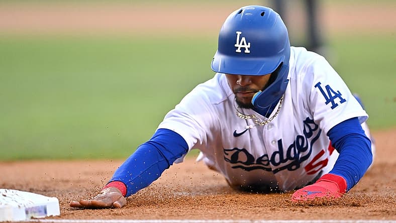 Jul 22, 2022; Los Angeles, California, USA; Los Angeles Dodgers right fielder Mookie Betts (50) dives back to first on a pick off attempt in the first inning against the San Francisco Giants at Dodger Stadium. Mandatory Credit: Jayne Kamin-Oncea-USA TODAY Sports