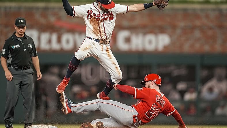 Jul 23, 2022; Cumberland, Georgia, USA; Atlanta Braves shortstop Dansby Swanson (7) has to jump over a sliding Los Angeles Angels first baseman Jared Walsh (20) during the sixth inning at Truist Park. Mandatory Credit: Dale Zanine-USA TODAY Sports