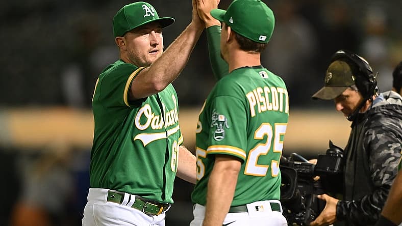 Jul 23, 2022; Oakland, California, USA; Oakland Athletics relief pitcher Zach Jackson (61) and right fielder Stephen Piscotty (25) shake hands after the final out of the ninth inning against the Texas Rangers at RingCentral Coliseum. Mandatory Credit: Robert Edwards-USA TODAY Sports