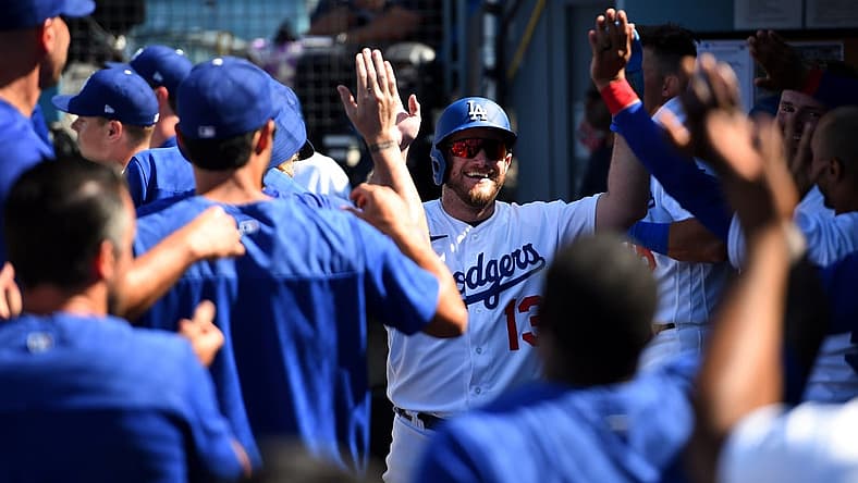 Jul 24, 2022; Los Angeles, California, USA; Los Angeles Dodgers third baseman Max Muncy (13) celebrates with his team in the dug out after scoring a run against the San Francisco Giants during the seventh inning at Dodger Stadium. Mandatory Credit: Jonathan Hui-USA TODAY Sports