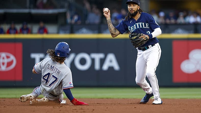 Jul 25, 2022; Seattle, Washington, USA; Seattle Mariners shortstop J.P. Crawford (3) holds back from throwing to first base after getting a force out against Texas Rangers left fielder Josh Smith (47) during the third inning at T-Mobile Park. Mandatory Credit: Joe Nicholson-USA TODAY Sports
