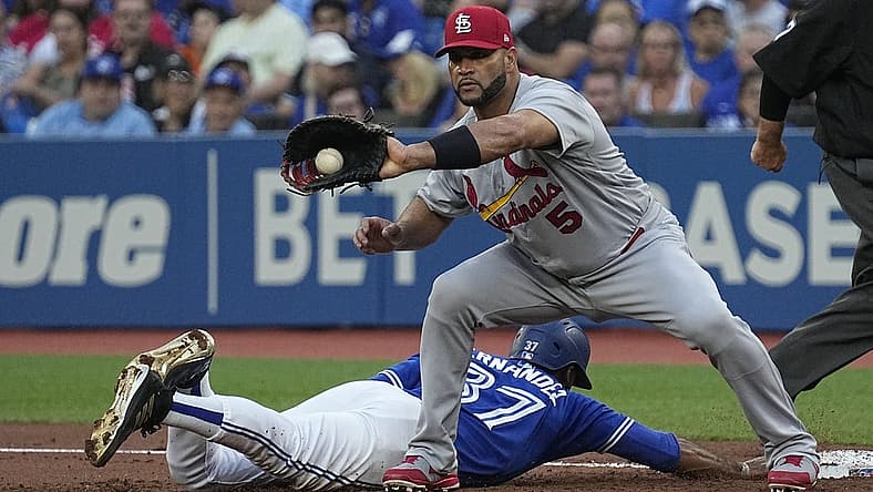 Jul 26, 2022; Toronto, Ontario, CAN; St. Louis Cardinals first baseman Albert Pujols (5) makes a catch on a throwback against Toronto Blue Jays right fielder Teoscar Hernandez (37) during the first inning at Rogers Centre. Mandatory Credit: John E. Sokolowski-USA TODAY Sports