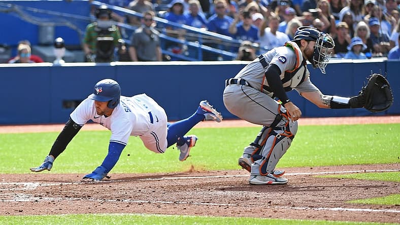Jul 30, 2022; Toronto, Ontario, CAN; Toronto Blue Jays designated hitter George Springer (4) dives past Detroit Tigers catcher Eric Haase (13) to score in the sixth inning after a Toronto Blue Jays short stop Bo Bichette (11) (not shown) sacrifice fly at Rogers Centre. Mandatory Credit: Gerry Angus-USA TODAY Sports