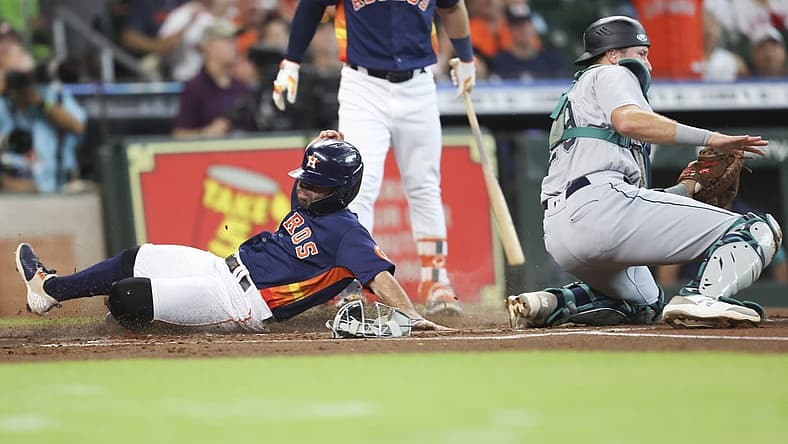 Jul 31, 2022; Houston, Texas, USA; Houston Astros second baseman Jose Altuve (27) steals home plate as Seattle Mariners catcher Cal Raleigh (29) awaits the throw in the first inning at Minute Maid Park. Mandatory Credit: Thomas Shea-USA TODAY Sports