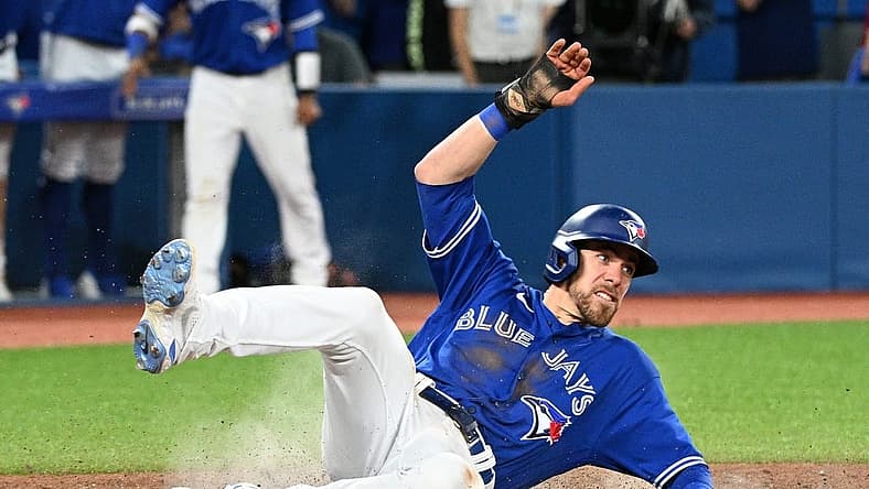 Jun 28, 2022; Toronto, Ontario, CAN; Toronto Blue Jays pinch runner Bradley Zimmer (7) slides across home plate after scoring against the Boston Red Sox in the ninth inning at Rogers Centre. Mandatory Credit: Dan Hamilton-USA TODAY Sports