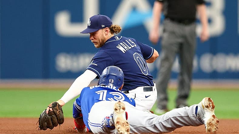 Aug 3, 2022; St. Petersburg, Florida, USA; Toronto Blue Jays left fielder Lourdes Gurriel Jr. (13) runs out a double while Tampa Bay Rays shortstop Taylor Walls (0) applies a tag in the first inning at Tropicana Field. Mandatory Credit: Nathan Ray Seebeck-USA TODAY Sports