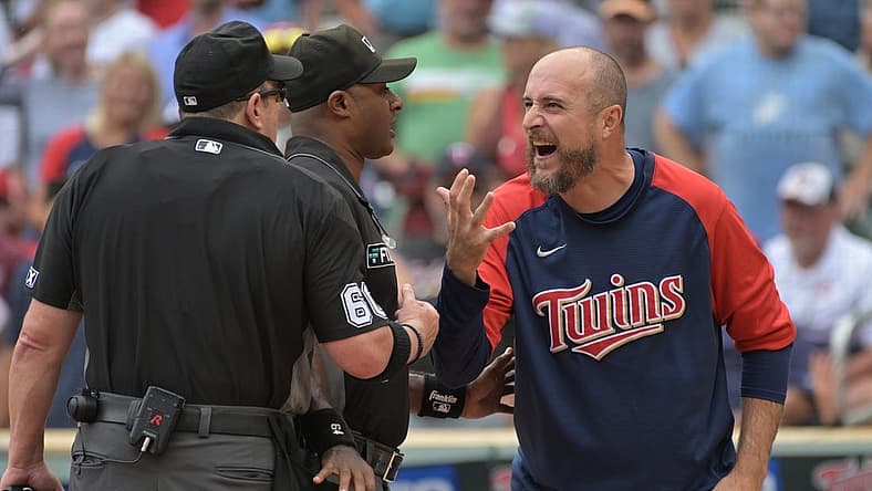 Aug 7, 2022; Minneapolis, Minnesota, USA; Minnesota Twins manager Rocco Baldelli (5) reacts with umpire Marty Foster (60) and umpire Alan Porter (64) to an overturned call during the tenth inning at Target Field. Mandatory Credit: Jeffrey Becker-USA TODAY Sports
