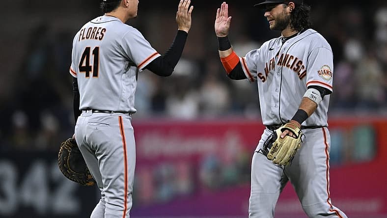 Aug 8, 2022; San Diego, California, USA; San Francisco Giants shortstop Brandon Crawford (right) and first baseman Wilmer Flores (41) celebrate after defeating the San Diego Padres at Petco Park. Mandatory Credit: Orlando Ramirez-USA TODAY Sports