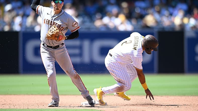 Aug 10, 2022; San Diego, California, USA; San Francisco Giants second baseman Wilmer Flores (left) throws to first base late after forcing out San Diego Padres center fielder Trent Grisham (2) at second base during the third inning at Petco Park. Mandatory Credit: Orlando Ramirez-USA TODAY Sports