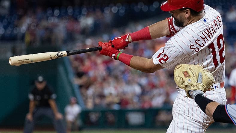 Aug 10, 2022; Philadelphia, Pennsylvania, USA; Philadelphia Phillies left fielder Kyle Schwarber (12) hits an RBI single during the eighth inning against the Miami Marlins at Citizens Bank Park. Mandatory Credit: Bill Streicher-USA TODAY Sports