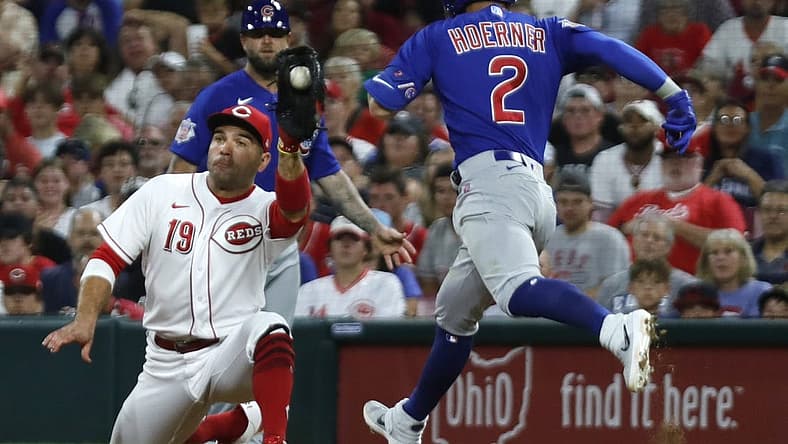 Aug 13, 2022; Cincinnati, Ohio, USA; Chicago Cubs shortstop Nico Hoerner (2) is out at first against Cincinnati Reds first baseman Joey Votto (19) during the sixth inning at Great American Ball Park. Mandatory Credit: David Kohl-USA TODAY Sports