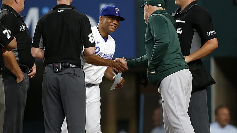 Aug 15, 2022; Arlington, Texas, USA; Texas Rangers interim manager Tony Beasley (27) shakes hands with Oakland Athletics manager Mark Kotsay (7) and the umpiring crew before a game at Globe Life Field. Mandatory Credit: Tim Heitman-USA TODAY Sports