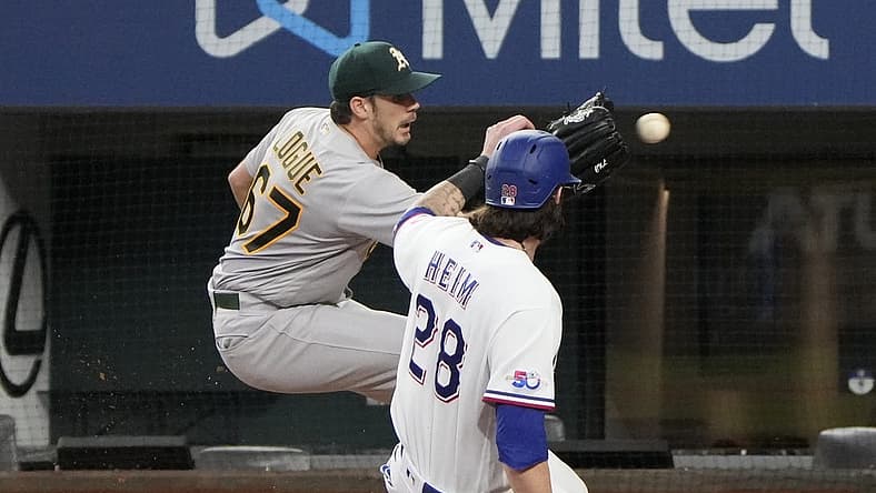 Aug 18, 2022; Arlington, Texas, USA; Texas Rangers catcher Jonah Heim (28) slides as he is tagged out at home by Oakland Athletics starting pitcher Zach Logue (67) during the second inning at Globe Life Field. Mandatory Credit: Jim Cowsert-USA TODAY Sports