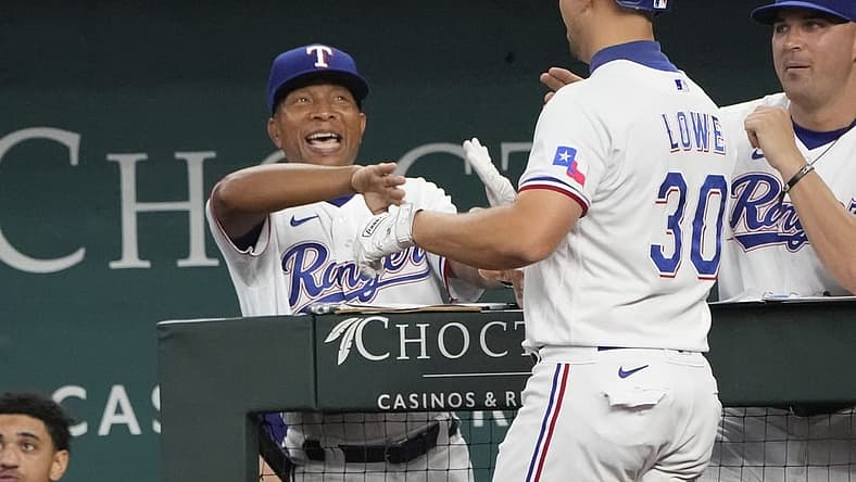Aug 18, 2022; Arlington, Texas, USA; Texas Rangers first baseman Nathaniel Lowe (30) is congratulated by interim manager Tony Beasley (27) as he arrives to the dugout after hitting a three-run home run against the Oakland Athletics during the fifth inning at Globe Life Field. Mandatory Credit: Jim Cowsert-USA TODAY Sports