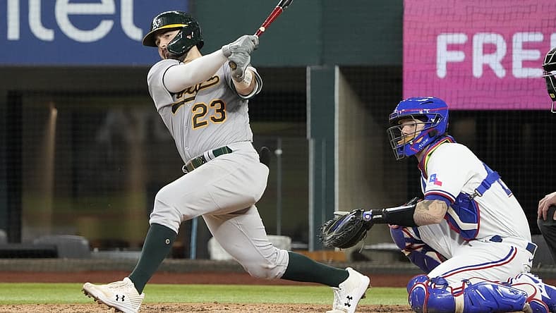Aug 18, 2022; Arlington, Texas, USA; Oakland Athletics catcher Shea Langeliers (23) hits a double in front of Texas Rangers catcher Jonah Heim (28) during the seventh inning at Globe Life Field. Mandatory Credit: Jim Cowsert-USA TODAY Sports