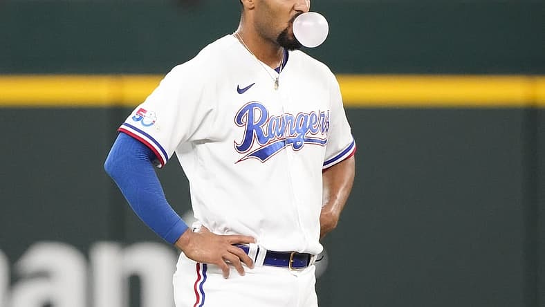 Aug 18, 2022; Arlington, Texas, USA; Texas Rangers second baseman Marcus Semien (2) pauses to blow a bubble between pitches to the Oakland Athletics during the seventh inning at Globe Life Field. Mandatory Credit: Jim Cowsert-USA TODAY Sports