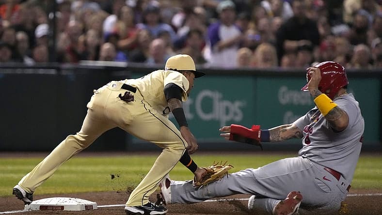 Aug 19, 2022; Phoenix, Arizona, USA; St. Louis Cardinals catcher Yadier Molina (4) gets tagged out by Arizona Diamondbacks third baseman Josh Rojas (10) in the fourth inning at Chase Field. Mandatory Credit: Rick Scuteri-USA TODAY Sports