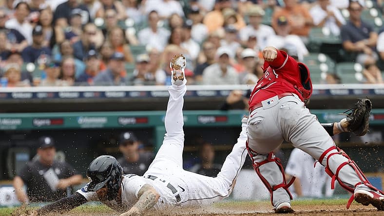 Aug 20, 2022; Detroit, Michigan, USA; Detroit Tigers designated hitter Eric Haase (13) dives in safe at home ahead of the tag by Los Angeles Angels catcher Max Stassi (33) in the third inning at Comerica Park. Mandatory Credit: Rick Osentoski-USA TODAY Sports